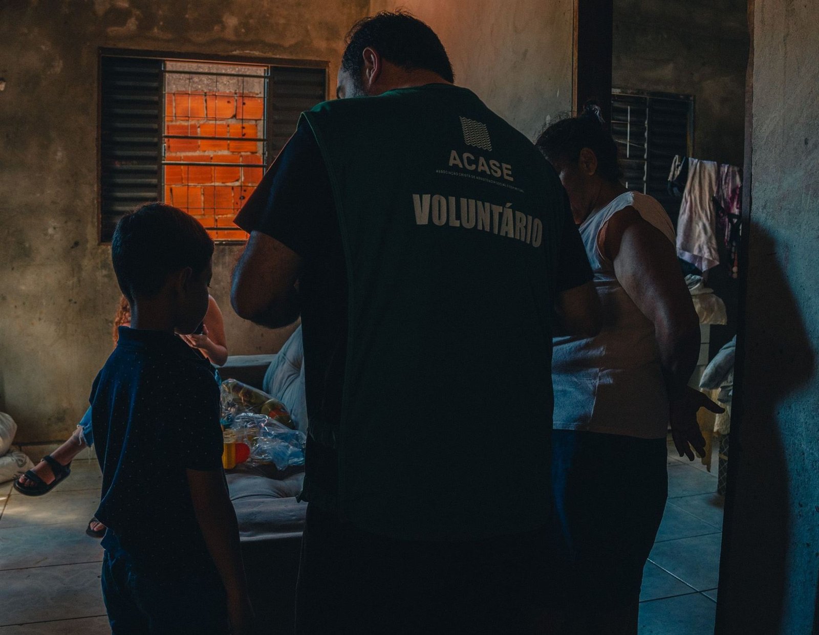 Voluntário da ACASE visita uma família em casa.