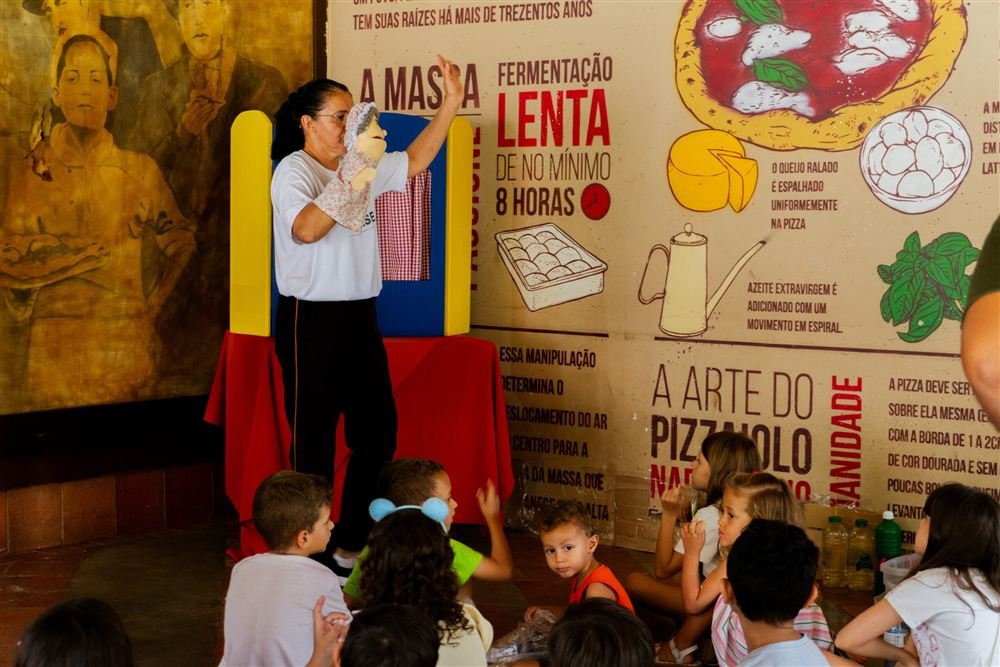 Voluntária da ACASE apresenta um teatro de fantoches para crianças.