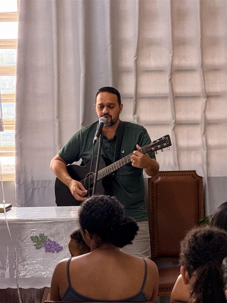 Voluntário da ACASE toca violão e canta num culto dentro do hospital.